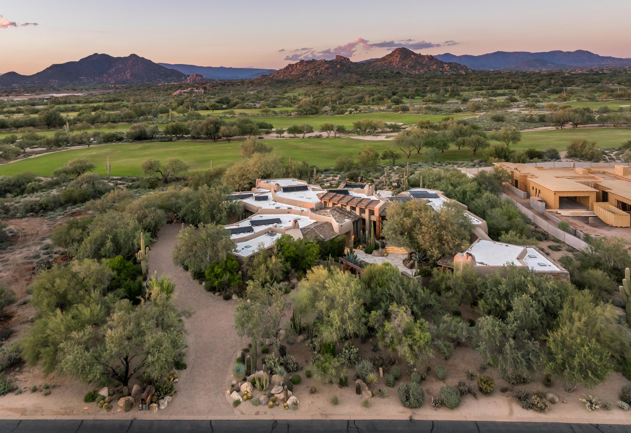 The residence, desert landscape and golf course in the warm light of sunset.