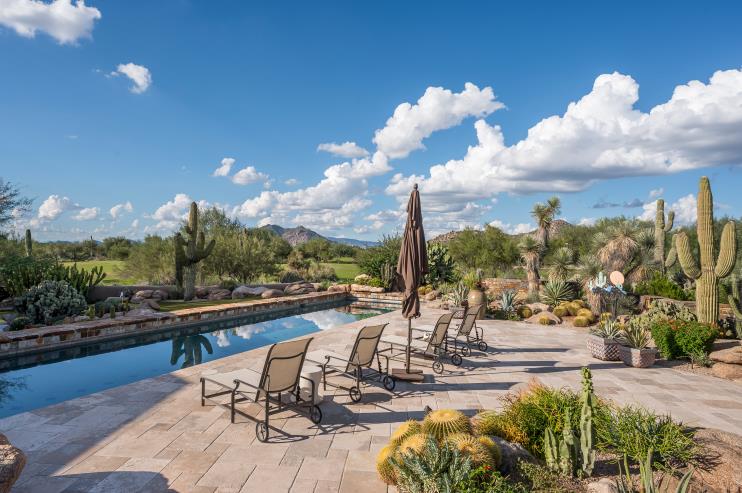 Poolside dining and seating overlook the desert landscape.